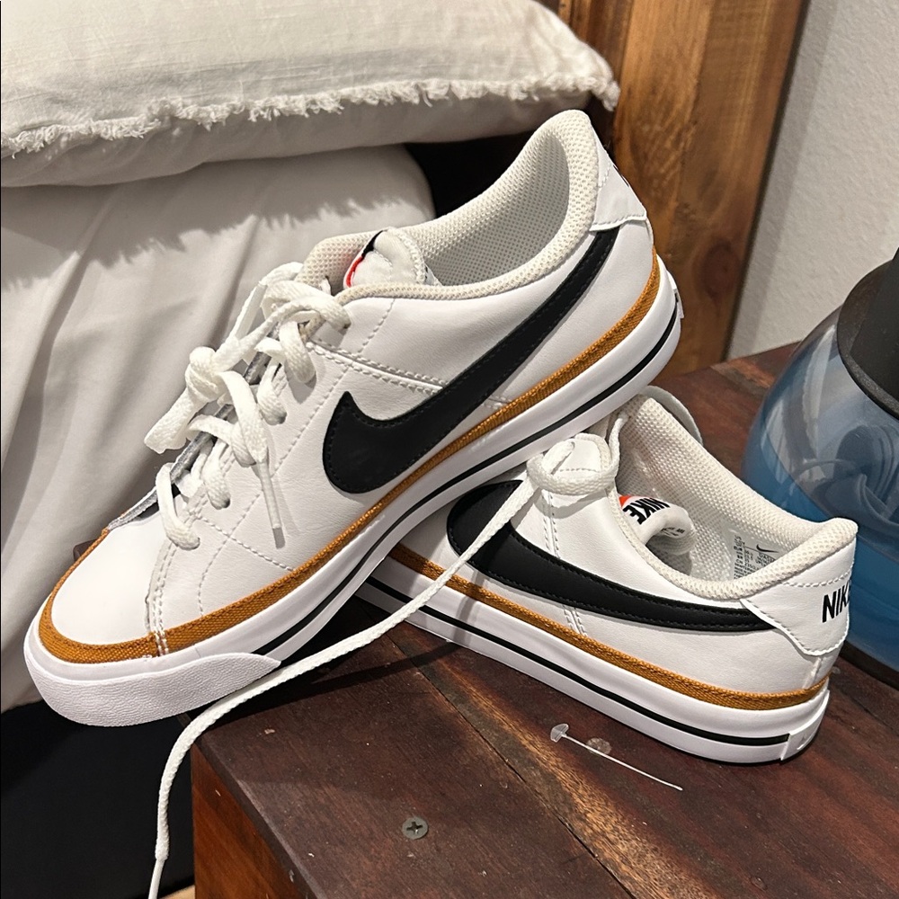 Nike White Leather Sneakers with Black Swoosh and Gold Accent